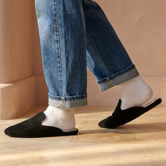 Woman in black leather mule slippers at home