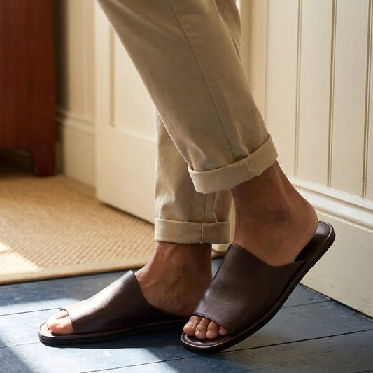Man in brown leather open toe slippers at home