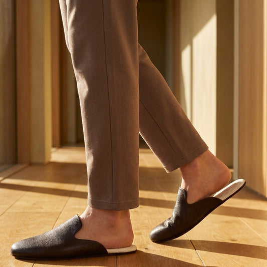 Man in brown leather mule slippers at home