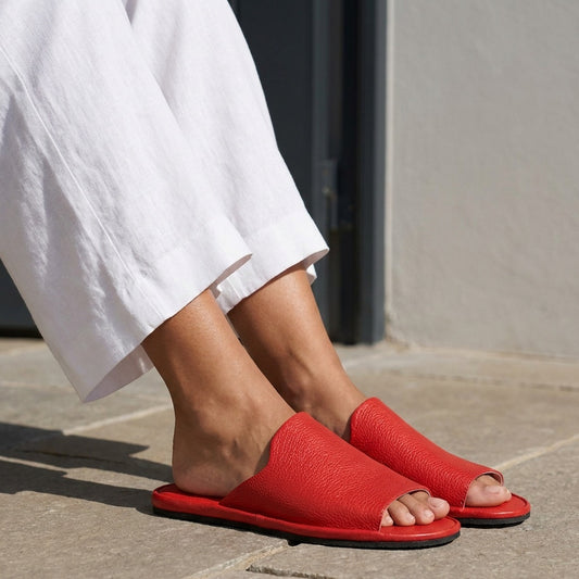 Woman in red leather open toe slippers on a terrace