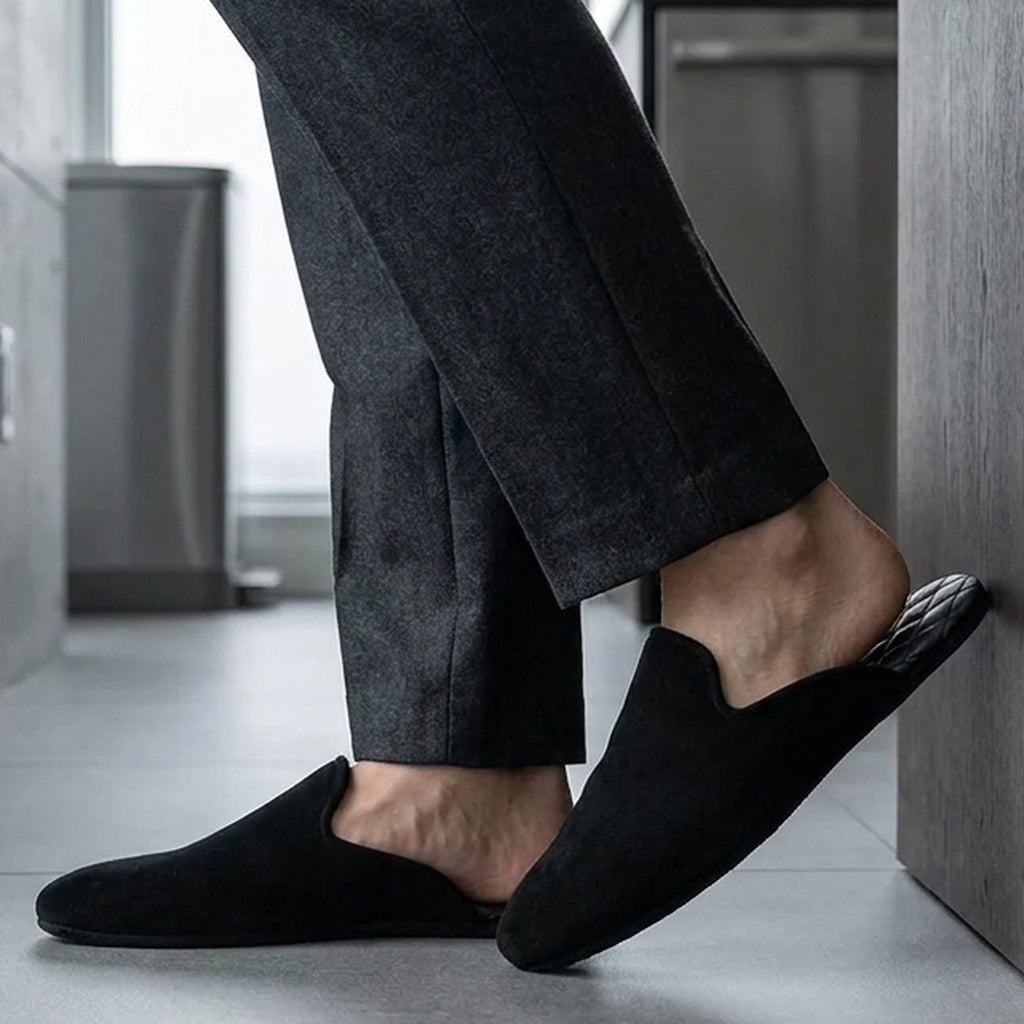 Man in black leather mule slippers at home