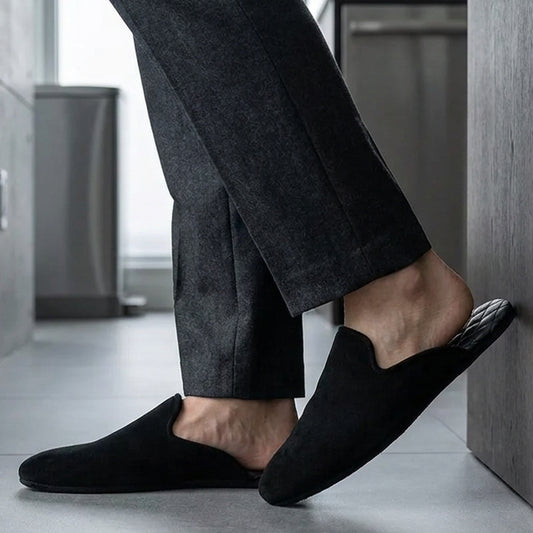 Man in black leather mule slippers at home