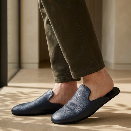 Man in navy leather mule slippers at home